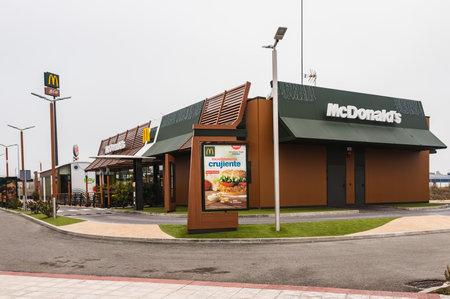 Sarriguren, Spain - December 19, 2021 - Close-up of a McDonald's restaurant next to a sign advertising a crispy hamburger. In the background the Burger King logo. Strongcompetition.のeditorial素材