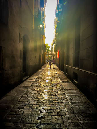 A young couple walk down a narrow street with a neon Ramen sign.の写真素材