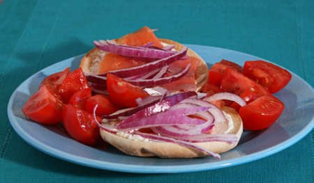 Lox and bagel sandwich with onions and tomatoes on a plate
