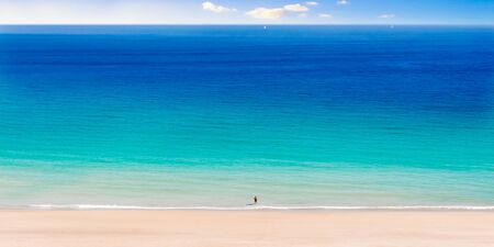 Huge Beach with Single Person Standing in the Water