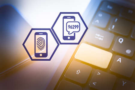 Two Hexagon Icons symbolising Secure Athetication in Front of a Smartphone and a Laptop Computerの写真素材