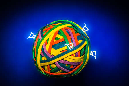 Ball of Colorful Rubber Bands Symbolising the Earth with Shopping Cartsの写真素材