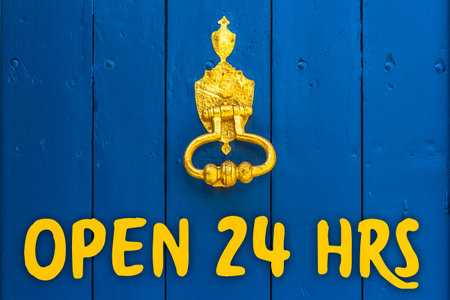 The Words Open 24 Hours written on a Blue Door with a Golden Door Knockerの写真素材