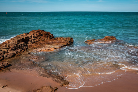 Rocky coastline against ocean and blue skyの写真素材