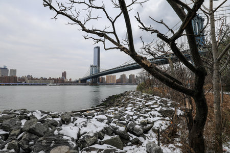 View of Manhattan Bridge with snow covered foreground in winter, New York City, United States.の写真素材