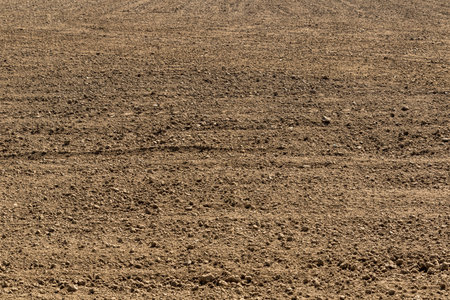 View of a ploughed field ready for planting in rural Australia, showcasing neat furrows, rich soil,...