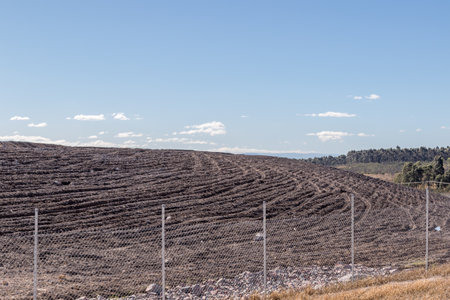 View of a ploughed field ready for planting, showcasing neat furrows, rich soil, and open farmland...