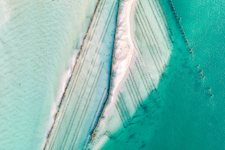 A breathtaking aerial view showcasing turquoise ocean waters, white sandy beaches, and a bridgeの写真素材