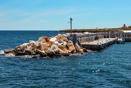 Tabarca Island, Alicante, Spain - May, 14, 2016: Pier of Tabarca Island with barrier for waves in shape of stone heap in Mediterranean Sea. Tabarca located close to Santa Pola, Alicante.のeditorial素材