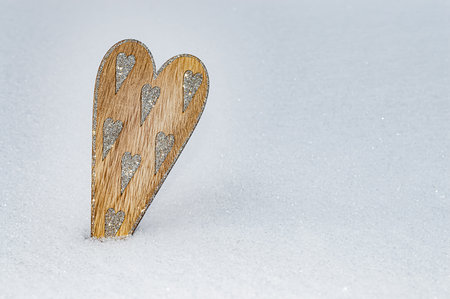 Wooden heart with many sharpen silver glittering hearts in snow, love concept.の写真素材