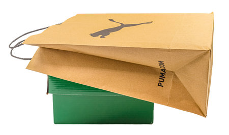 Dnipro, Ukraine - January, 5, 2021: Paper bag with black PUMA logo on green cardboard box isolated...