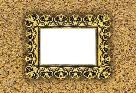 Golden painted frame with repeating abstract elements on sandstone color wall.の写真素材