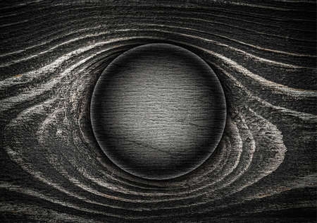 Dark round wooden sign board on wooden background with wavy stripes.の写真素材