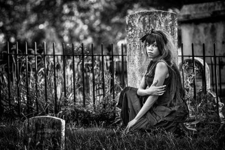 Beautiful african american gothic woman in a graveyard. Black and white photo with added film grain. Moody photo expressing depression, loneliness, abadnonment and more. Very old cemetery. の写真素材