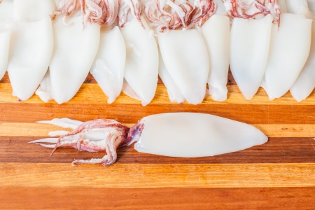 Fresh cleaned squid laying out on a cutting board ready to be preparedの写真素材