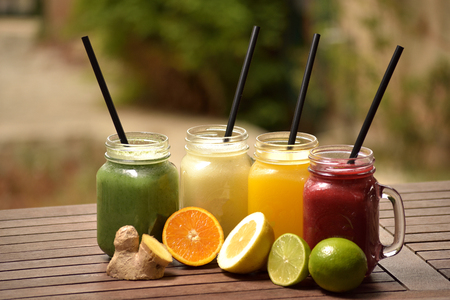 Varied fruit juices in carafe in the gardenの写真素材