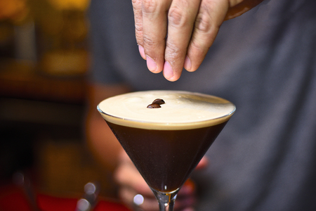 bartender adding coffee grains in espresso martiniの写真素材