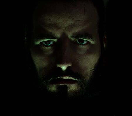 portrait of angry bearded man with green lighting.