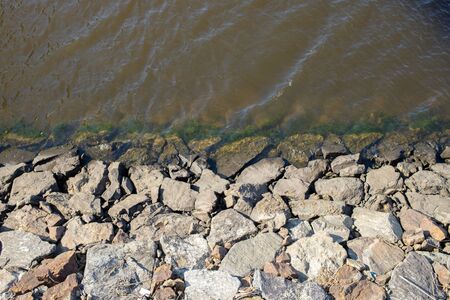 stone-paired breakwater and calm river.の写真素材