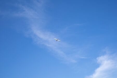 a small plane seen far into the blue sky.の写真素材