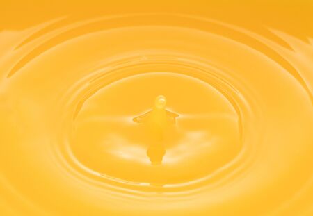 the waves after a few drops of orange juice.の写真素材