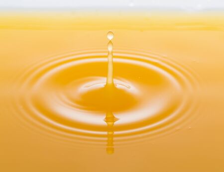 the waves after a few drops of orange juice.の写真素材