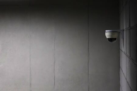 a security camera installed on a concrete wall.の写真素材