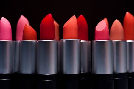 any of various colored lipstick in a case made of black plastic and steel.の写真素材