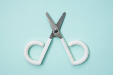 Little cute scissors on a light blue backgroundの写真素材