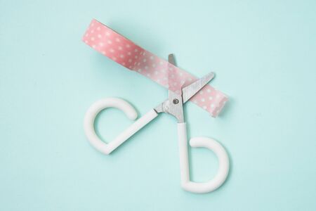 small cute scissors to cut pink paper tape.の写真素材