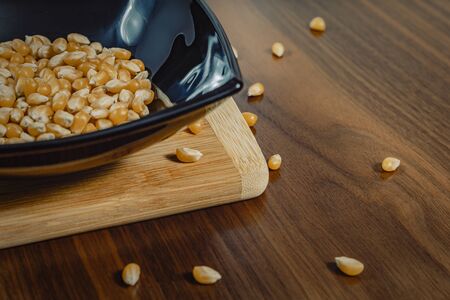 bowl with raw corn seeds on wooden tableの写真素材