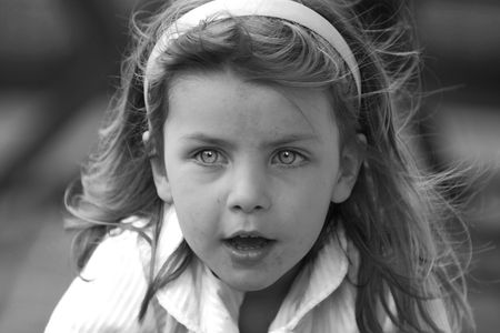 Black and White shot of a messy young girl with a blue filter - giving the eyes an electric haunting...