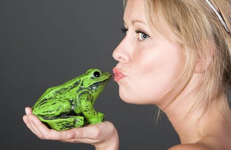 Shot of a Pretty Blonde Girl Kissing a Frogの写真素材