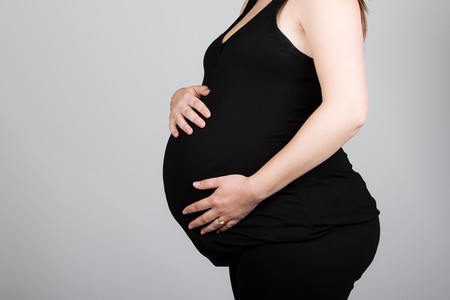 Shot of a Pregnant Woman in Black Clothes against Grey Backgroundの写真素材