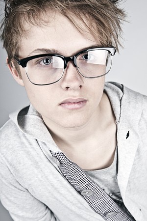 Shot of a Geeky Looking Teenager against Grey Backgroundの写真素材