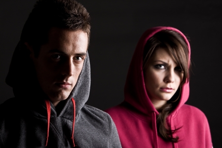 Two Hooded Teenagers against Dark Backgroundの写真素材