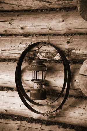 Old Fashion Gas Lantern handing on log cabin with metal bandsの写真素材