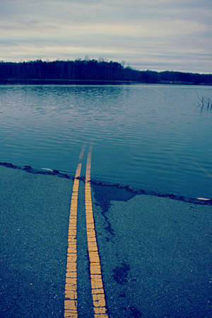 Paved road going into the water, to create a dam lakeの写真素材