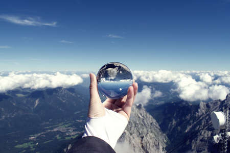 View from Zugspitze of rocky cliff and valley below reflected in crystal ballの写真素材