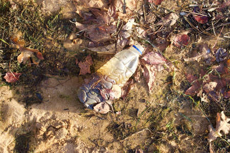 Plastic water bottle washed up on river shoreline