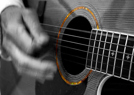 Person playing acoustic guitar with only color the detailing around the sound hole.
