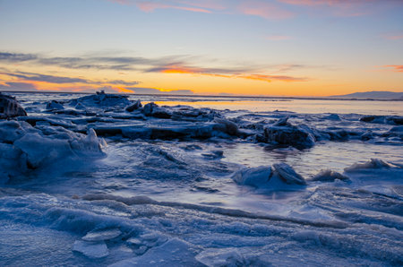 Sunset over the ocean and cracked ice field, on a winter day in Iceland.