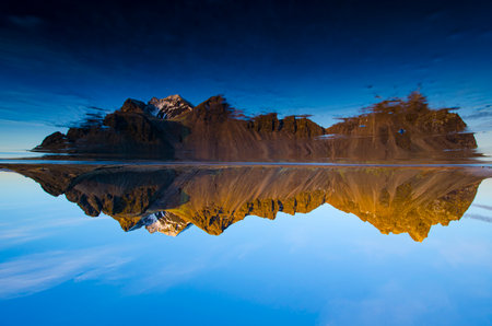View of Iceland's Vestrahorn mountain with relfection in ice layer.の写真素材