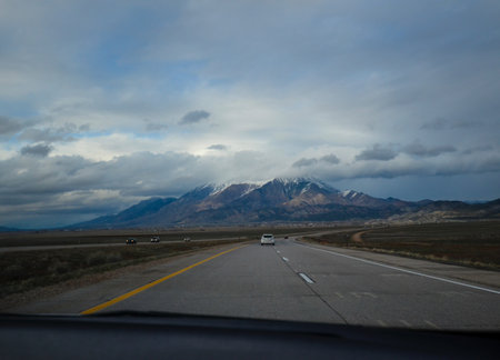 View of the road and southwest landscape from passenger seat of the car.