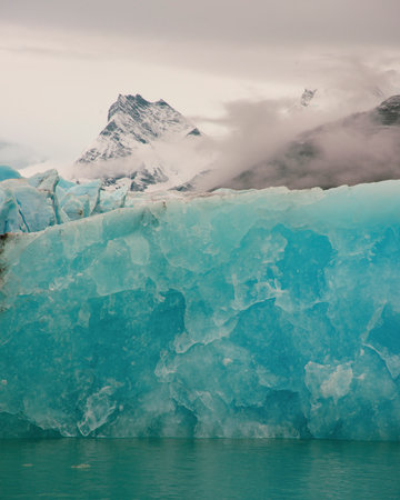 View of the Glacier edge with misty mountain in the background.  In Los Glaciares National Park in...