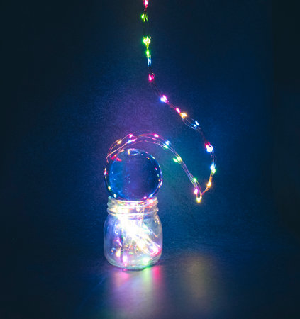 Led lights leading down to glass Mason Jar with blue purple background.の写真素材
