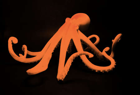 Stone octopus with dark background in bold, bright colors.