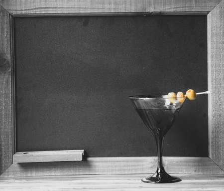 Cocktail drink in front of chalkboard for the drink menu, with tropical wood tableの写真素材