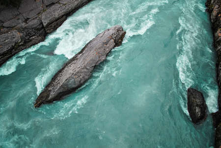 Fast-flowing aqua-colored River in Loom Norway, creating white water around gray rocks.の写真素材
