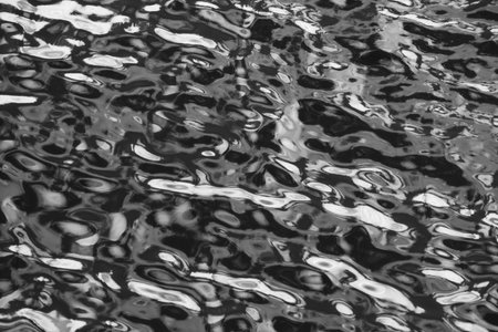 Black and white abstract background of water surface with ripples and wavesの写真素材